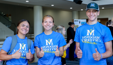 Students wearing blue FYE t-shirts smile for the camera